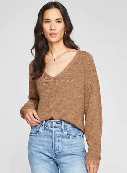 Woman wearing a cool caramel color sweater with denim.