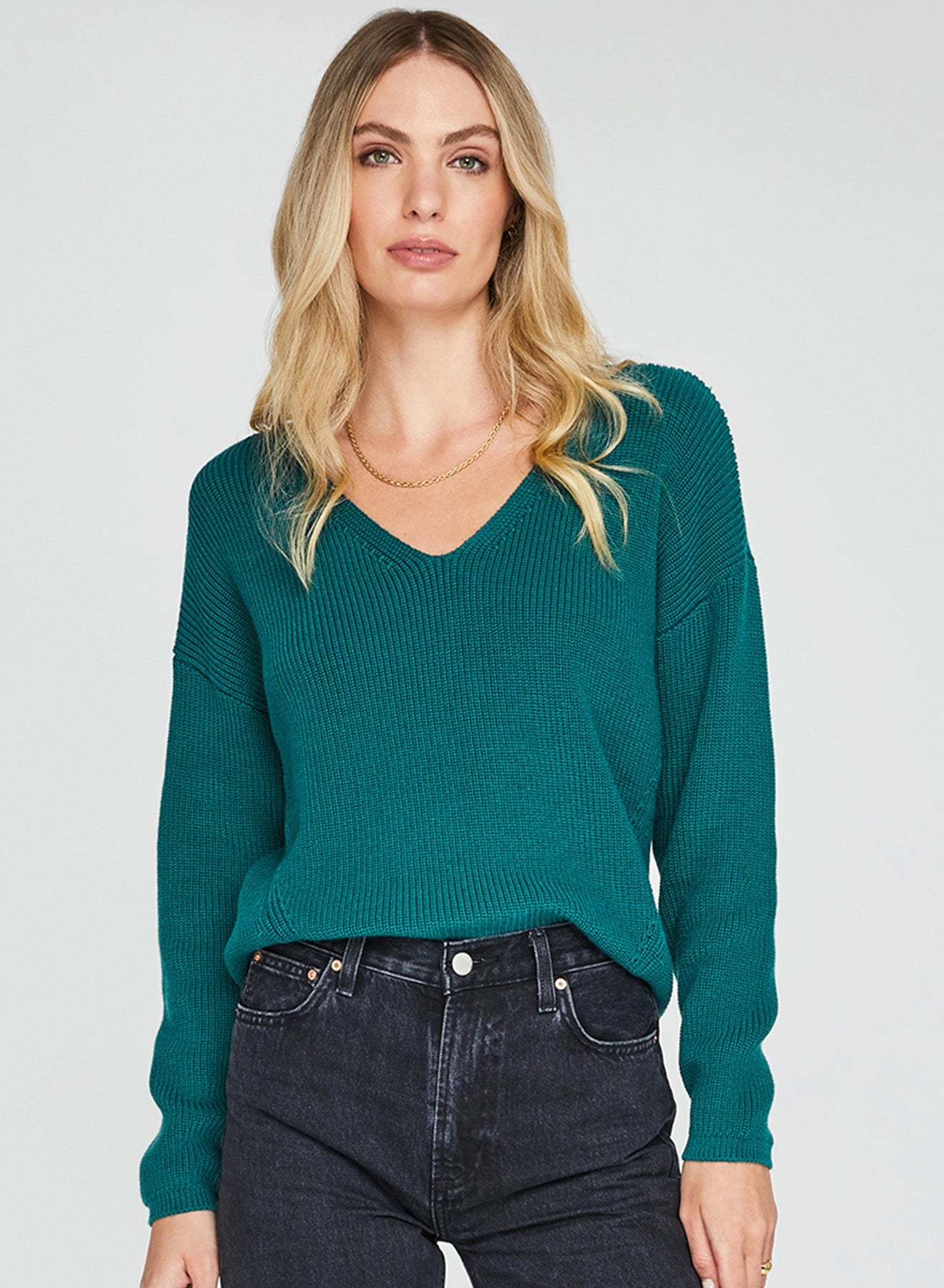 Woman wearing an emerald green sweater for holiday.